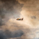 An emergency aircraft flies through the smoke.